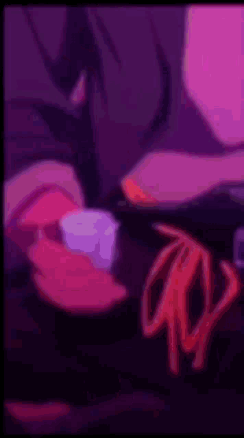 a person is holding a cup in their hand in a pink and purple background .