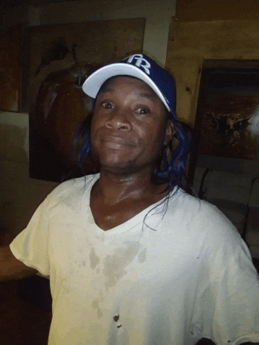 a man wearing a white shirt and a blue hat with the letters fr on it