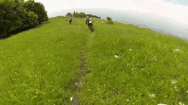 a person riding a dirt bike on a grassy hillside