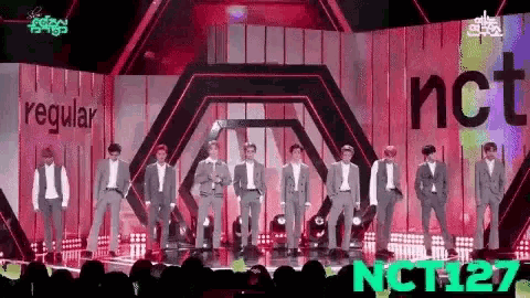 a group of men are standing on a stage .