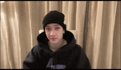 a young man wearing a black beanie and a black hoodie .