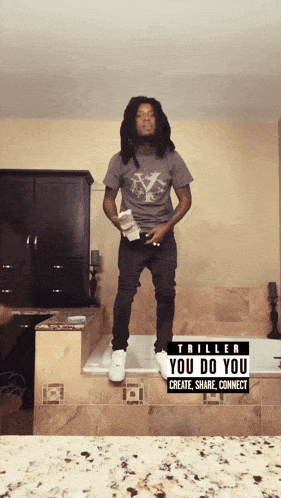a man is standing in front of a bathtub with a sign that says triller you do you create share connect