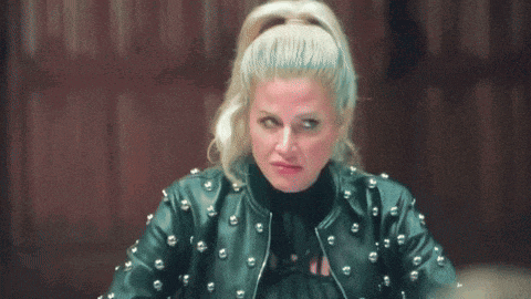 a woman wearing a studded leather jacket is making a face