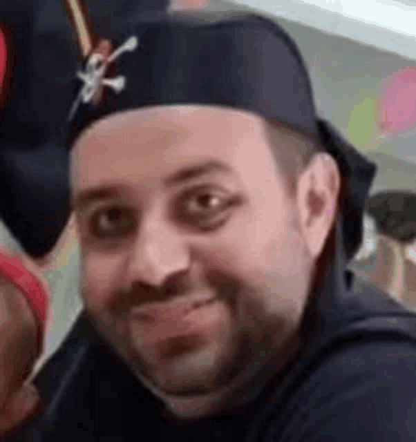 a man is wearing a pirate hat and smiling at the camera .