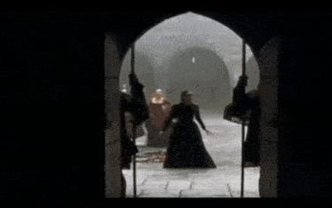 a group of people are standing in a dark room looking out a window