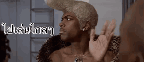 a man with blonde hair and a leopard print jacket is giving the ok sign .