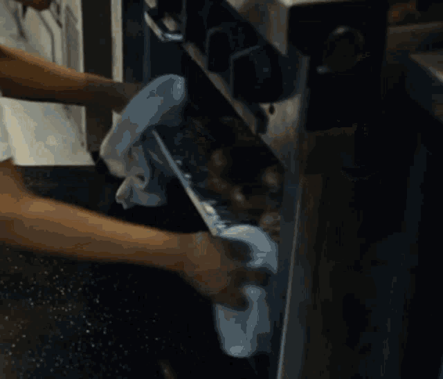 a person is cleaning a tray of food with a cloth