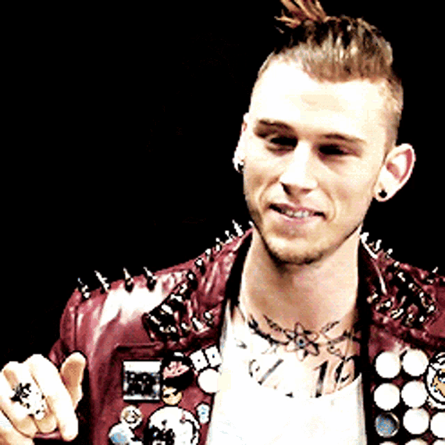 a man with a tattoo on his neck is wearing a jacket with spikes on it