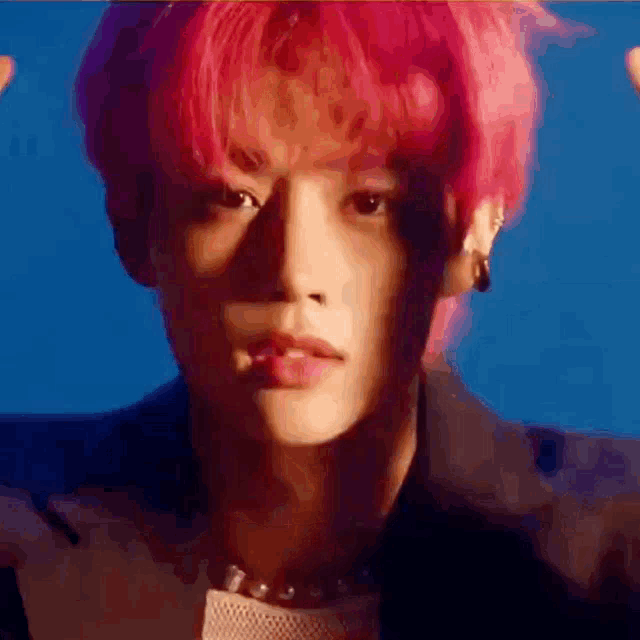 a close up of a person 's face with pink hair .