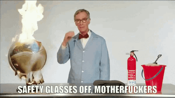 a man stands in front of a fire extinguisher and a bucket with the words safety glasses off motherfuckers