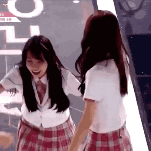 two girls in school uniforms are standing next to each other and smiling