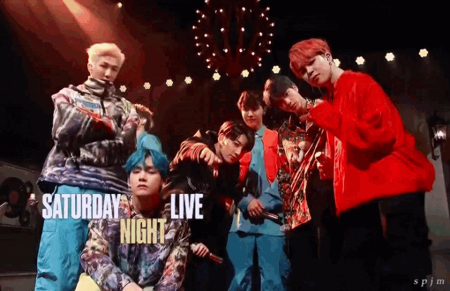 a group of young men standing on a stage with saturday night live written on the bottom right