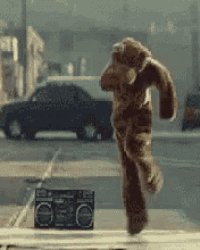 a stuffed animal is running down a street next to a boombox .