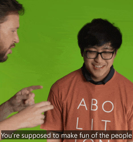 a man is pointing at another man who is wearing a shirt that says abo lit