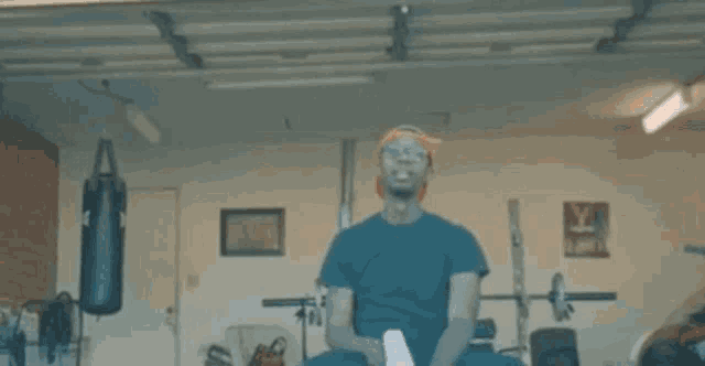 a man is boxing in a garage with a red light coming out of his eyes .