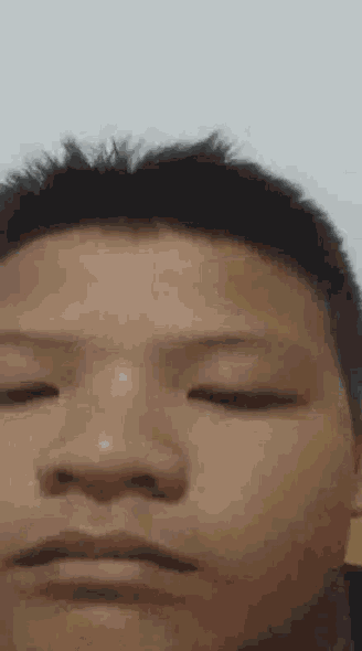 a close up of a man 's face with his eyes closed .