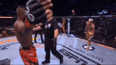 a referee stands in a boxing ring with espn written on the floor