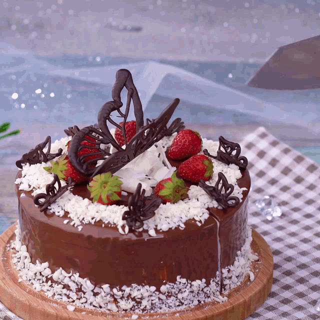 a chocolate cake with strawberries and coconut on it