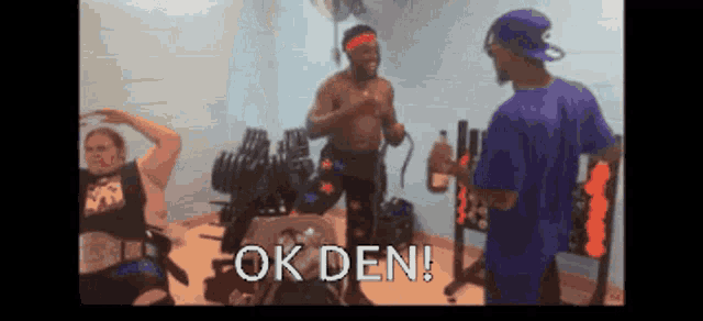 a man in a blue shirt says ok den while standing next to a man in a black tank top