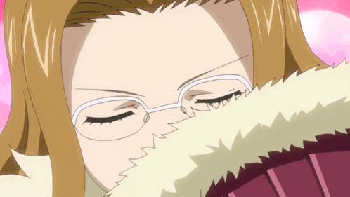 a woman wearing glasses covering her face with a furry blanket
