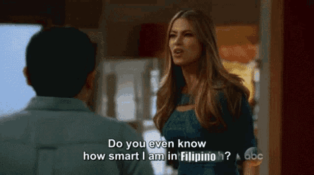 a woman in a blue dress is talking to a man in a living room .