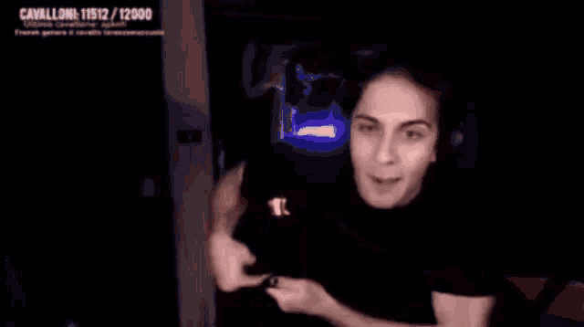 a woman is sitting in front of a computer screen with a horseshoe in the background .