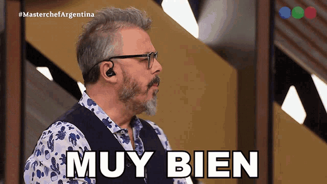 a man with a beard and earbuds says muy bien