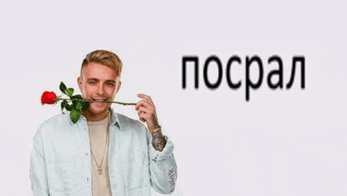 a man is holding a red rose in his mouth and smiling .