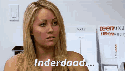 a woman with blonde hair says " underdaad " in front of a stack of teen vogue magazines