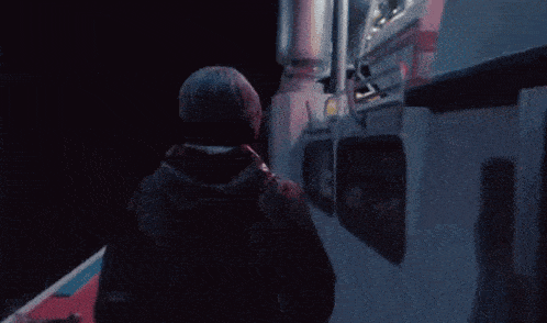 a man is standing on the side of a boat looking out the window .