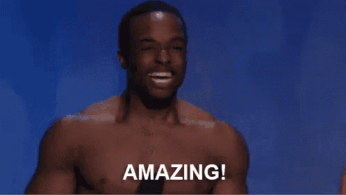 a shirtless man is sitting in front of a microphone with the words `` amazing '' written on the screen .