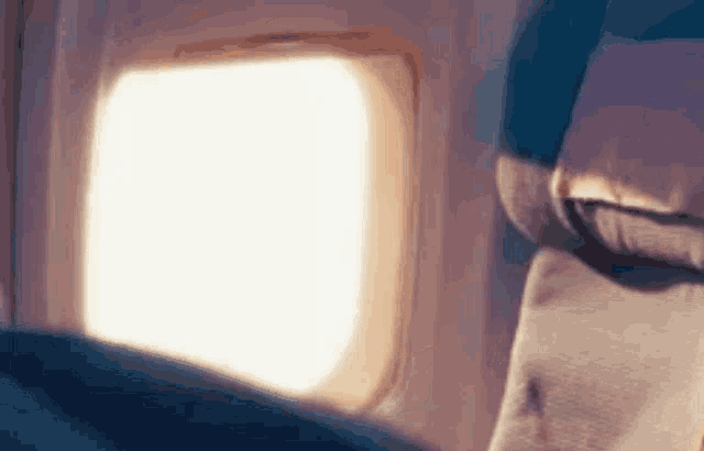 a close up of a person sitting on an airplane looking out the window .