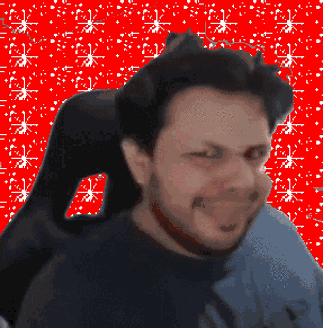 a man with a beard is sitting in a chair with a red background