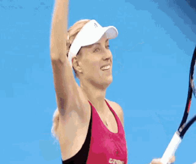 a woman is holding a tennis racquet on a blue court .