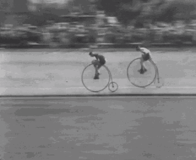 a man riding a bicycle with a large wheel