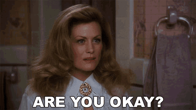 a woman says are you okay in front of a pink towel