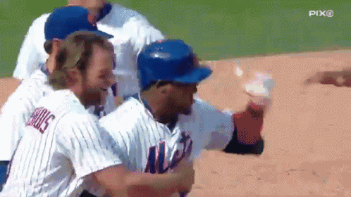 a group of baseball players are hugging each other on the field