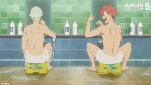two naked men sit on yellow boxes in a bathroom with kaiju 8 written on the wall