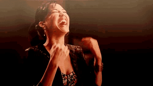 a woman is laughing with her mouth open