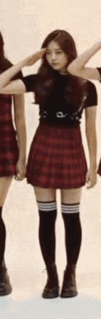a girl wearing a plaid skirt and black knee high socks
