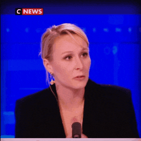 a woman is talking into a microphone in front of a c news sign