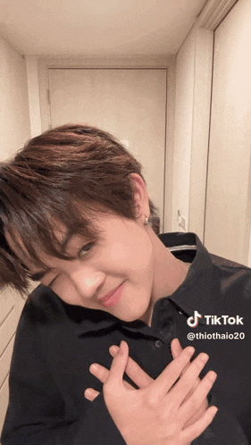 a young man in a black shirt has a tiktok sticker on his shirt