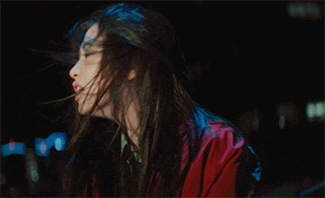 a woman in a red jacket is screaming with her mouth wide open