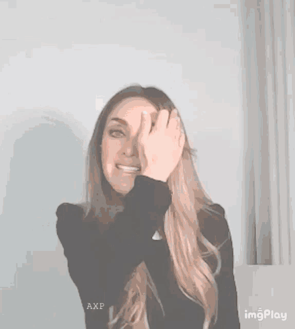 a woman is covering her face with her hand and the word axp is on the bottom right