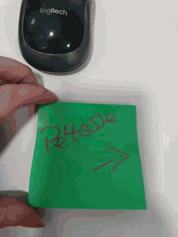 a logitech mouse is next to a green piece of paper that says release