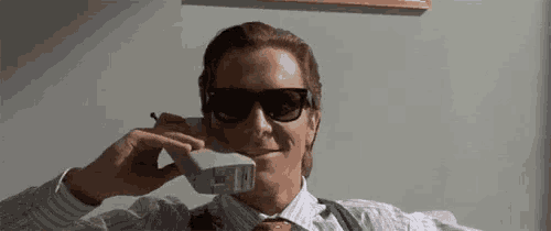 a man wearing sunglasses is talking on a cellphone