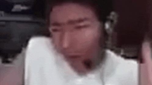 a man wearing headphones and a white shirt is sitting in a chair with his eyes closed .