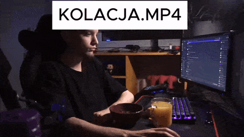 a man sitting in front of a computer with kolacja.mp4 written on the screen