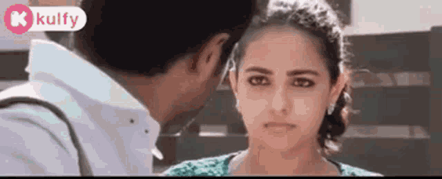 a man and a woman are looking at each other with a kulfy logo in the corner .