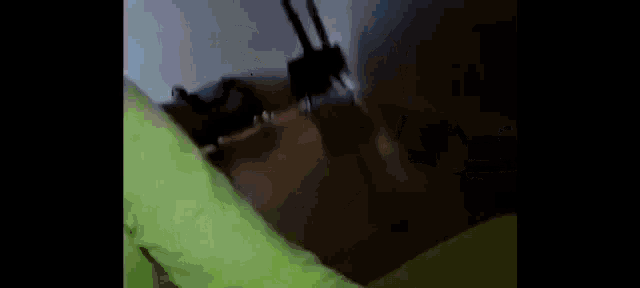 a blurry picture of a person standing in a room with a green blanket .
